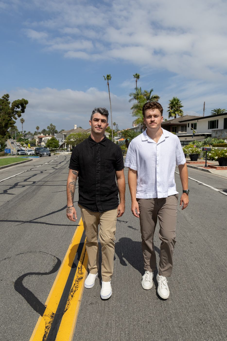 Clay Smith and Dylan Doumeng walking down a palm-lined street in coastal Orange County